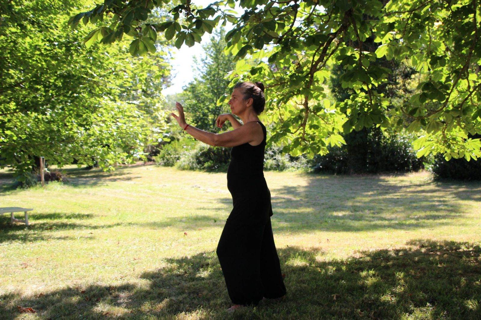 woman in black sleeveless dress standing on green grass field during daytime